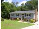 Inviting two-story home with landscaped yard, charming brick accents, and lush green lawn at 4408 Leota Dr, Raleigh, NC 27603
