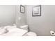 Half-bathroom featuring a sink, toilet, mirror, and artwork at 4828 Morning Edge Dr, Raleigh, NC 27613