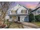 Charming two-story home with a front porch, a well-manicured lawn, and an attached garage at 4828 Morning Edge Dr, Raleigh, NC 27613