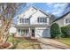 Charming two-story home with a front porch, a well-manicured lawn, and an attached garage at 4828 Morning Edge Dr, Raleigh, NC 27613