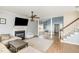 Open-concept living room with a fireplace, wood floors, and natural light at 4828 Morning Edge Dr, Raleigh, NC 27613