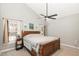 Spacious bedroom with a large wooden bed frame, ceiling fan, and two windows at 4828 Morning Edge Dr, Raleigh, NC 27613
