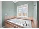 Bathroom featuring a white tub, a window, and neutral-colored tile surround at 504 Crooked Pine Dr, Cary, NC 27519