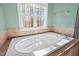 Bright bathroom featuring a white tub and a window with natural light at 504 Crooked Pine Dr, Cary, NC 27519