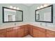 Bathroom featuring double sinks with wood cabinetry, mirrors and vanity lights at 504 Crooked Pine Dr, Cary, NC 27519