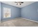 Bedroom with blue walls, neutral carpet, and natural light at 504 Crooked Pine Dr, Cary, NC 27519