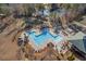 Aerial view of community pool, playground, and neighboring lake in a lush wooded area at 504 Crooked Pine Dr, Cary, NC 27519