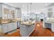 Bright kitchen with island, stainless steel appliances and hardwood floors leading to living room at 504 Crooked Pine Dr, Cary, NC 27519