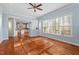 Open-concept living room with hardwood floors, a kitchen view, and natural light from large windows at 504 Crooked Pine Dr, Cary, NC 27519