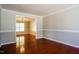 Open-concept dining room with hardwood floors and traditional chandelier, bathed in natural light at 5129 Chasteal Trl, Raleigh, NC 27610