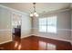 Formal dining room featuring hardwood floors, chandelier, and access to the kitchen at 5129 Chasteal Trl, Raleigh, NC 27610