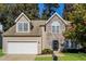 Charming two-story home featuring stone facade, attached garage, and well-maintained landscaping at 5129 Chasteal Trl, Raleigh, NC 27610
