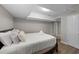 Basement bedroom with a large bed with a white comforter with neutral colors, and modern flooring at 5412 Farley Dr, Raleigh, NC 27609