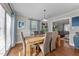 Bright dining room with hardwood floors, a wooden table with seating, and elegant curtains at 5412 Farley Dr, Raleigh, NC 27609
