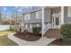A charming home's entrance with brick stairs, white railings and trim, with gray siding and well-maintained landscaping at 5412 Farley Dr, Raleigh, NC 27609
