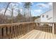 Back deck with wood railings offering views of neighboring houses and wooded area at 5439 Ripplebrook Rd, Durham, NC 27712