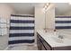 Bathroom featuring a double sink vanity with a large mirror and a shower with a striped curtain at 5439 Ripplebrook Rd, Durham, NC 27712