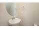 Half-bath with pedestal sink and round mirror, offering a simple and elegant design at 5439 Ripplebrook Rd, Durham, NC 27712