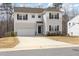 Inviting two-story home with attached garage, stone detail, neutral colors, and a spacious driveway at 5439 Ripplebrook Rd, Durham, NC 27712