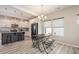 Open kitchen with stainless appliances, dark island, grey tile backsplash, and modern light fixtures at 5439 Ripplebrook Rd, Durham, NC 27712