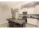 Open kitchen featuring white cabinets, stainless steel appliances, and an island with barstool seating at 5439 Ripplebrook Rd, Durham, NC 27712