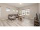 Inviting living room with wood floors, a comfortable gray sofa, and many windows at 5439 Ripplebrook Rd, Durham, NC 27712