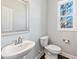 Bathroom features a pedestal sink, toilet, and a window offering natural light at 5501 Advancing Ave, Raleigh, NC 27616