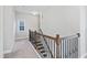 Upstairs hallway with carpet and wooden banister, leading to bedrooms at 5501 Advancing Ave, Raleigh, NC 27616