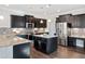 Island kitchen boasts dark wood cabinets, granite counters, and stainless steel appliances at 5501 Advancing Ave, Raleigh, NC 27616