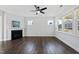 An empty living room boasts hardwood floors, a fireplace, and large windows at 5501 Advancing Ave, Raleigh, NC 27616