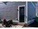 Side exterior door with a glass pane and gray siding at 5501 Advancing Ave, Raleigh, NC 27616