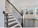 Elegant staircase with wood treads, an iron railing, and bright natural light streaming from the windows at 5501 Advancing Ave, Raleigh, NC 27616