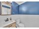 Stylish half-bathroom with blue walls, shiplap, and modern vanity at 6036 Epping Forest Dr, Raleigh, NC 27613