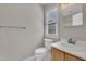 Bright bathroom with a window, a toilet, and a vanity with wood cabinets at 6036 Epping Forest Dr, Raleigh, NC 27613