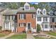 Charming brick townhouse featuring classic architecture, black shutters and well-manicured front yard at 6036 Epping Forest Dr, Raleigh, NC 27613