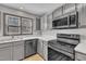 Well lit kitchen with stainless steel appliances and gray cabinets at 6036 Epping Forest Dr, Raleigh, NC 27613
