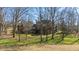 Lush backyard with a stately brick home nestled among mature trees at 6532 Wakefalls Dr, Wake Forest, NC 27587
