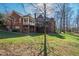 Scenic backyard view of the brick home highlighting the back deck, patio, and verdant lawn at 6532 Wakefalls Dr, Wake Forest, NC 27587