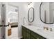 Bathroom features green cabinetry, marble countertops, and oval mirrors, viewed from bedroom doorway at 6532 Wakefalls Dr, Wake Forest, NC 27587