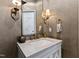 Chic powder room features a marble countertop and elegant fixtures and warm lighting at 6532 Wakefalls Dr, Wake Forest, NC 27587