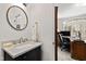 A modern bathroom with a marble countertop, stainless steel fixtures and a round mirror at 6532 Wakefalls Dr, Wake Forest, NC 27587