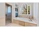 Bright bathroom features a soaking tub with large window and a glass-enclosed shower at 6532 Wakefalls Dr, Wake Forest, NC 27587