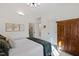 Bright bedroom with closet and bathroom entrances with white paint and a wood antique cabinet at 6532 Wakefalls Dr, Wake Forest, NC 27587