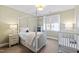 Bedroom bedroom with neutral decor featuring a four-poster bed, crib, and soft lighting at 6532 Wakefalls Dr, Wake Forest, NC 27587