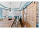 A dining room with rustic table, modern chandelier, blue walls and decorative wall paper at 6532 Wakefalls Dr, Wake Forest, NC 27587