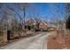 Elegant brick home nestled among mature trees, featuring a long driveway and classic architectural details at 6532 Wakefalls Dr, Wake Forest, NC 27587
