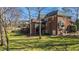 Backyard view featuring a large brick home with covered patios and lush green lawn and mature trees at 6532 Wakefalls Dr, Wake Forest, NC 27587