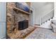 Living room stone fireplace with an ornate mantel, adjacent to a staircase and an archway at 6532 Wakefalls Dr, Wake Forest, NC 27587