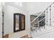 Elegant foyer with wrought iron double doors, staircase, wainscoting and hardwood floors at 6532 Wakefalls Dr, Wake Forest, NC 27587