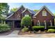 Stately brick home showcasing a manicured lawn, classic shutters and a welcoming, covered front porch at 6532 Wakefalls Dr, Wake Forest, NC 27587